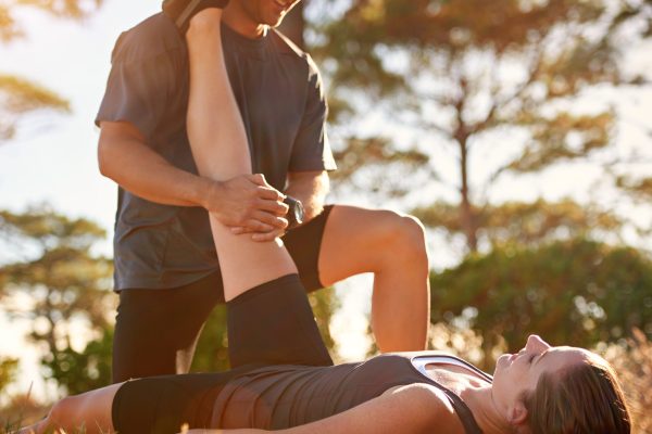 Let me lend you a hand. Shot of a young couple stretching together outside